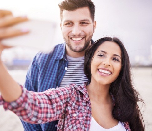 Man and woman taking a picture together and enjoying the benefits of Invisalign