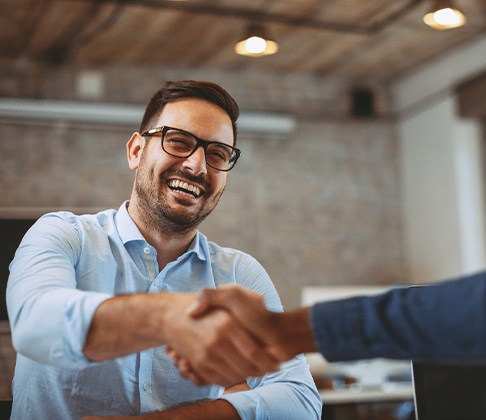 Sachse patient shaking hands with client after dental implants