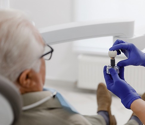 Older Sachse patient with dentist before dental implants