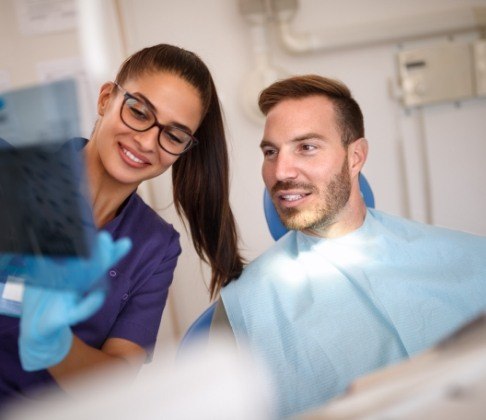 dentist and dental patient looking at x-rays during emergency dentistry visit
