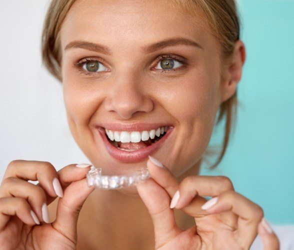 Woman placing Invisalign orthodontic treatment