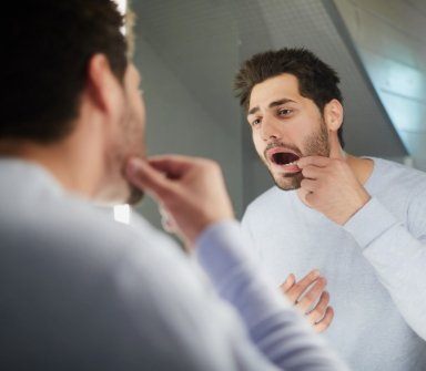 Man looking at damaged smile before emergency dentistry