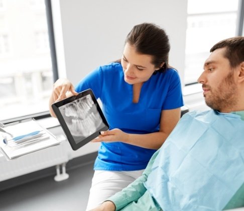 Dental team member and patient looking at all digital x-rays