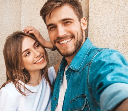 Man and woman with perfected smiles thanks to porcelain veneers